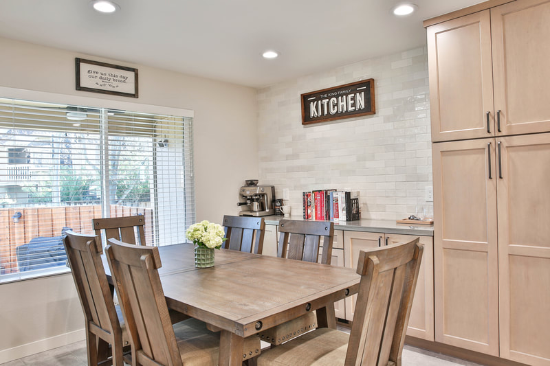 wood kitchen table with chairs and white tiled backsplash 
