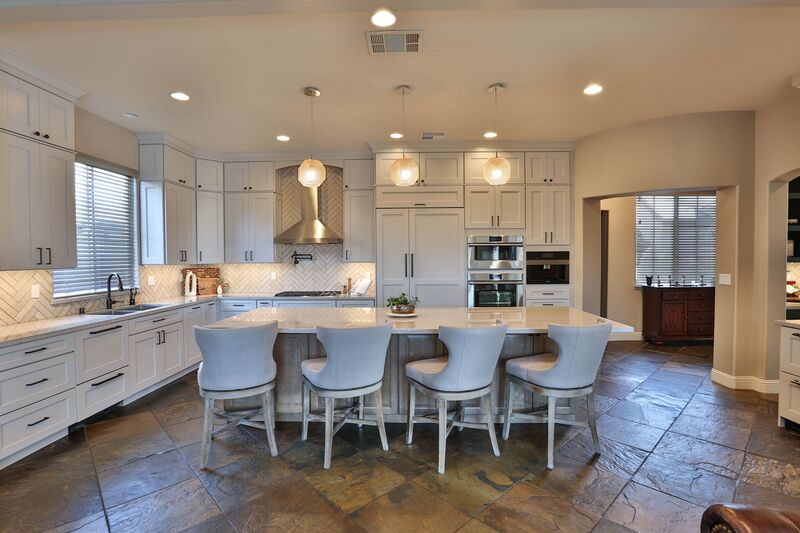 Transitional kitchen with white island and white cabinets.