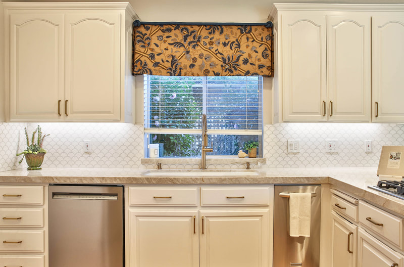 Kitchen with view of sink and white cabinets with custom curtain and white scale-shaped tile  